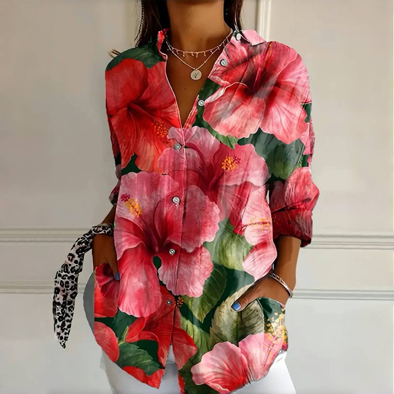 Woman wearing a bold oversized floral blouse in a relaxed flowy silhouette, shown in a rose print colorway