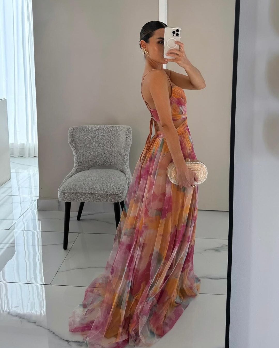 Close-up of the artistic floral print fabric on the orange maxi dress highlighting color and texture