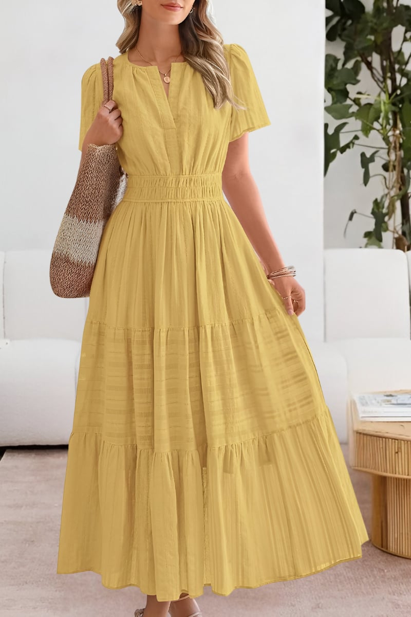 Woman wearing a flowing yellow boho summer dress with delicate pattern details, full-length view
