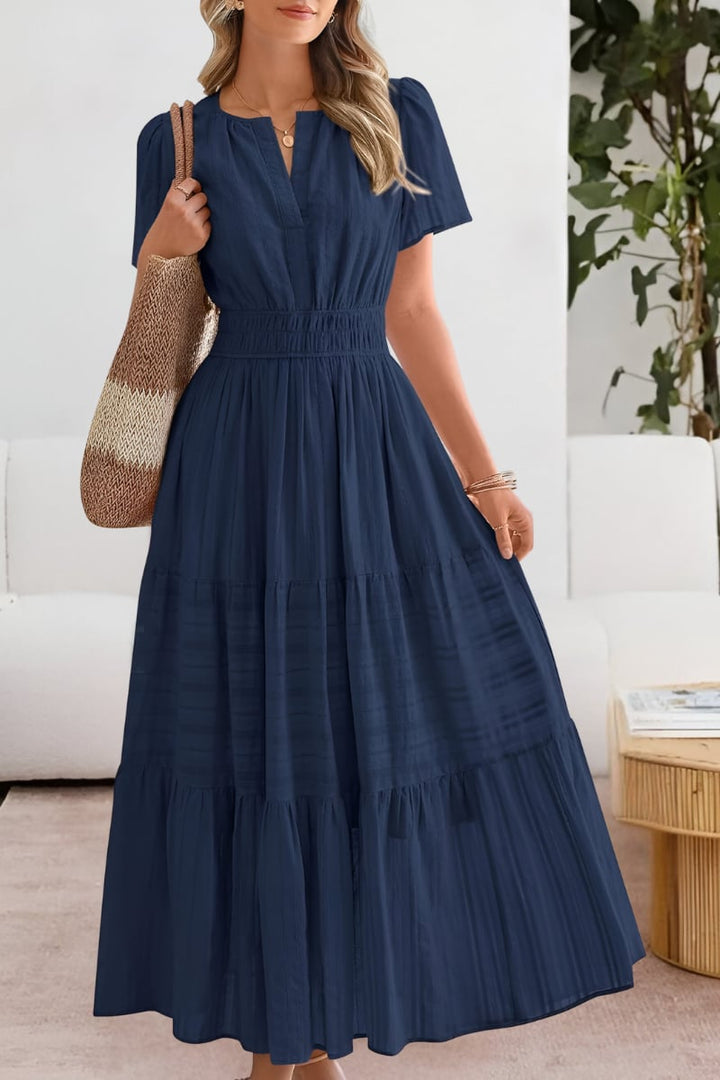 Model in a navy blue lightweight boho dress posed outdoors in warm weather