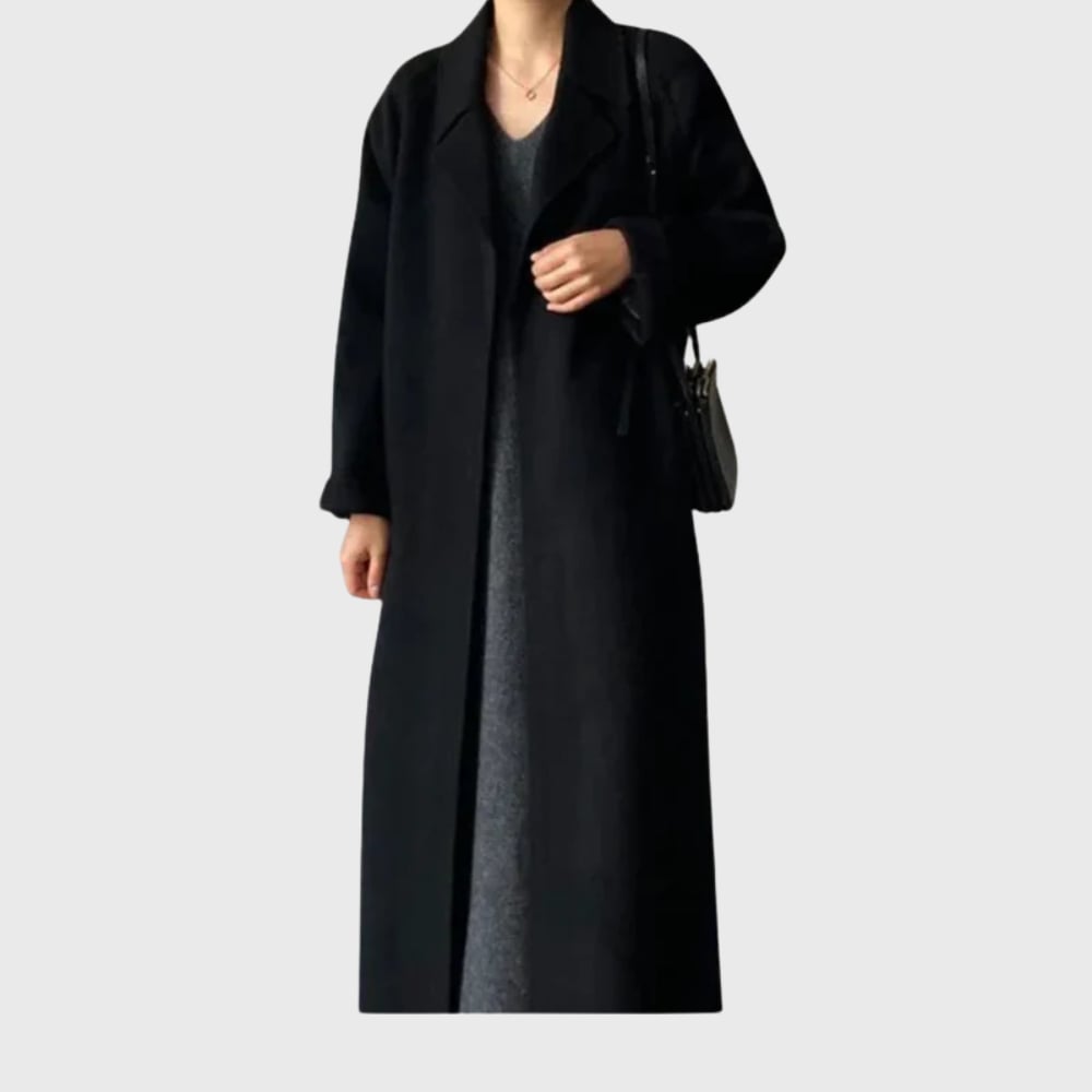 Woman in a black belted overcoat styled for an evening occasion with a polished look