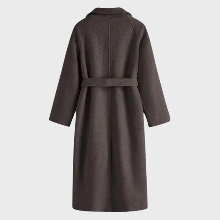 Model wearing the Florimay timeless belted overcoat in deep grey, walking outdoors in cold weather