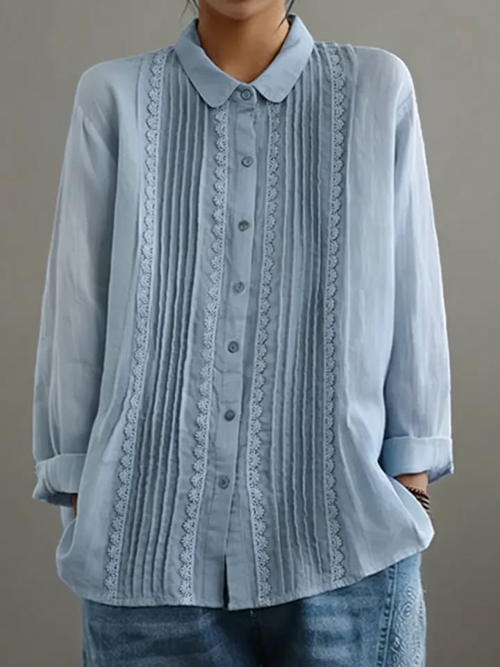Close-up of vertical lace trim panels framing the button placket on the Claire blouse in white