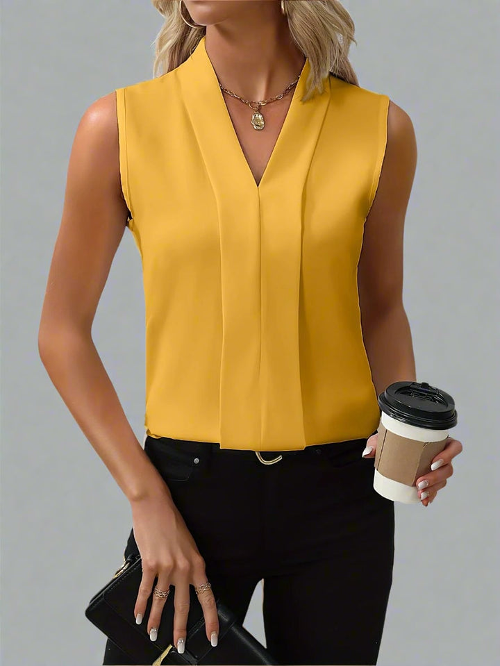 Back view of the Claire sleeveless pleated blouse showing clean, minimal silhouette