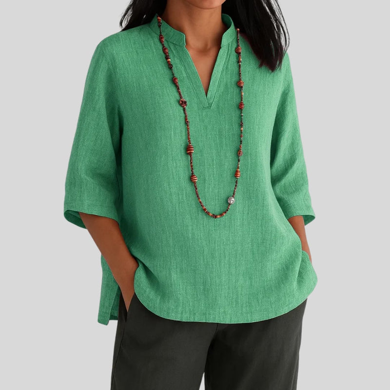 Woman wearing a relaxed-fit green blouse with a light, airy drape, styled for warm-weather wear