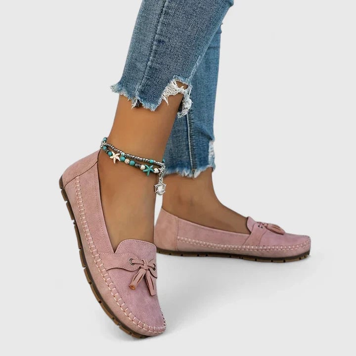 Pair of Clea suede bow moccasin flats in pink displayed on a neutral surface