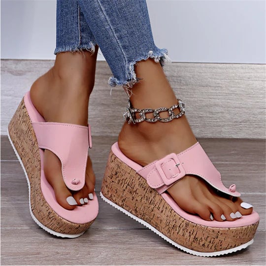 Cleo cork wedge sandals displayed in black, white, and pink colorways with thong toe strap and bow detail