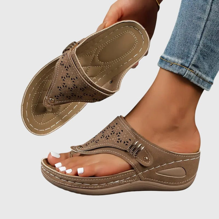 Close-up of the laser-cut floral detailing and gold stud on the toe strap of the Cleo sandal