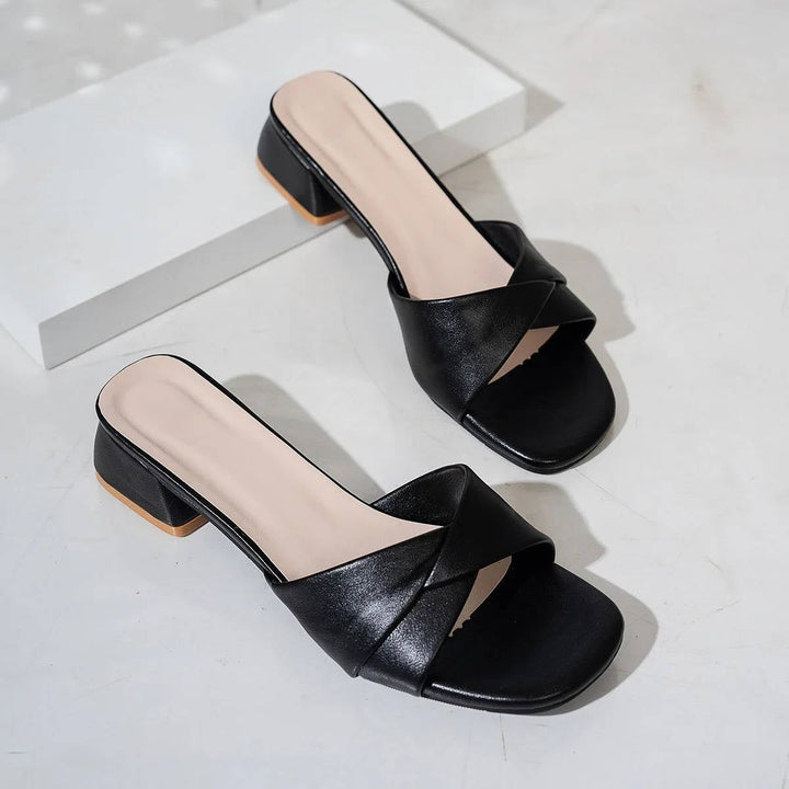 Clezza slide sandals in black worn on foot, lifestyle shot