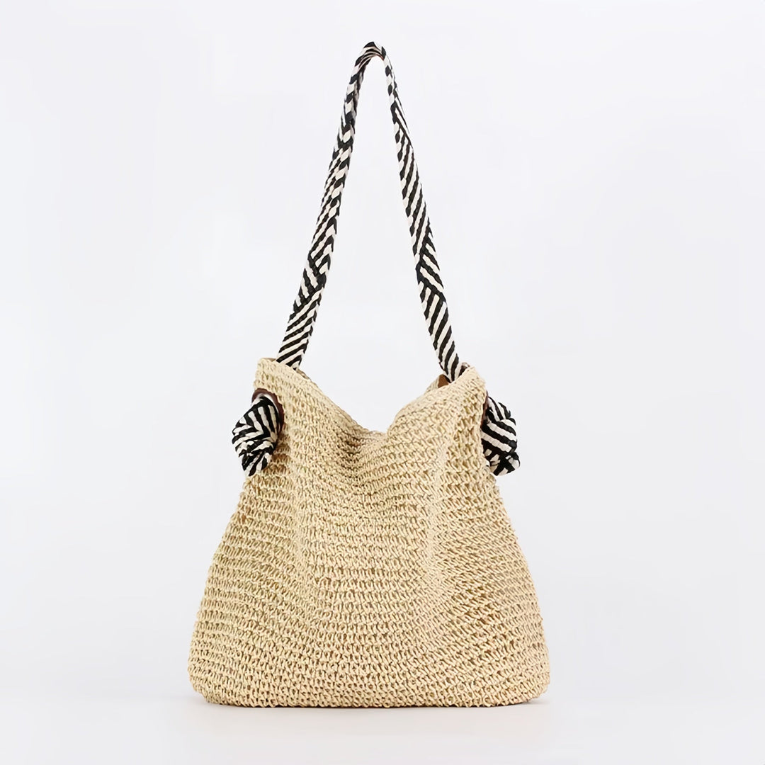 Boho shoulder bag in warm brown displayed at an angle to show sculptural silhouette and woven detail