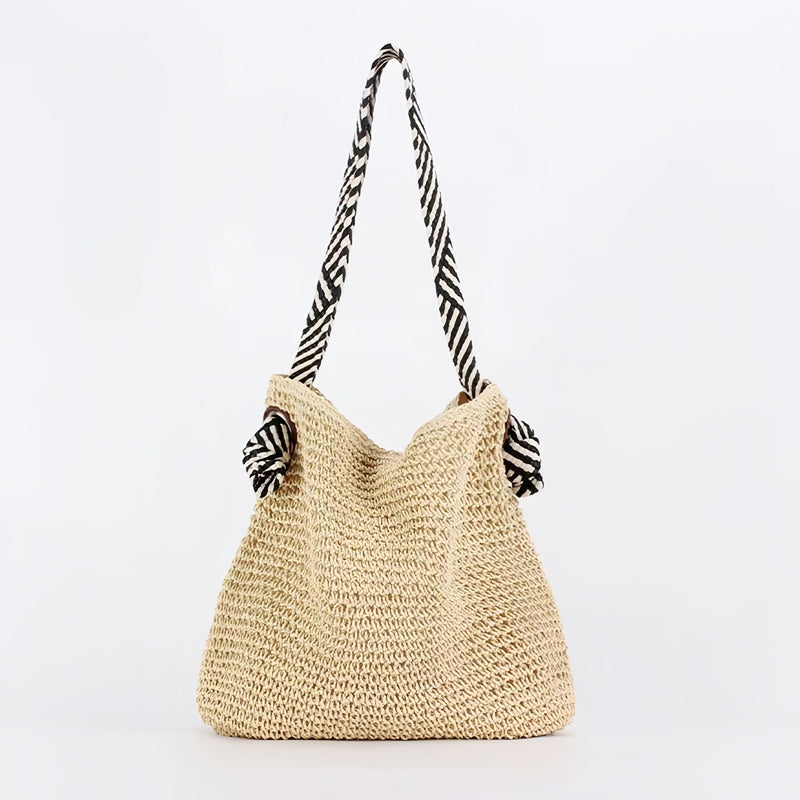 Boho shoulder bag in warm brown displayed at an angle to show sculptural silhouette and woven detail
