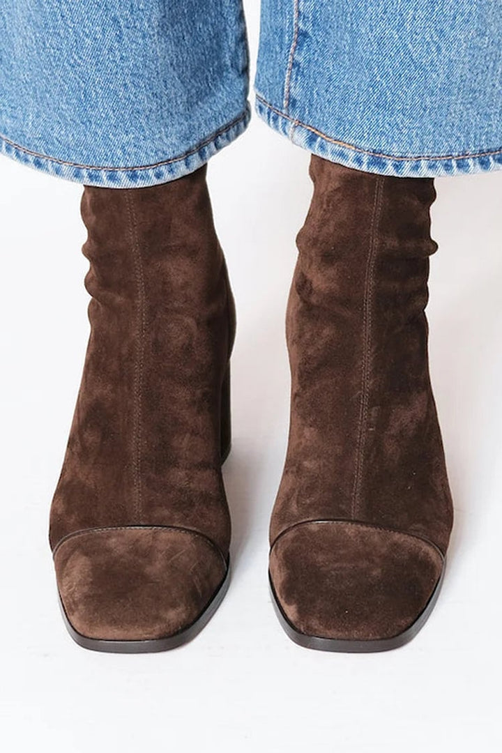 Close-up side view of dark brown orthopedic heeled boots highlighting the sole construction and elegant heeled silhouette