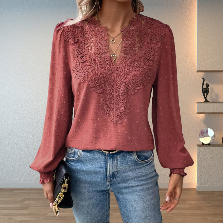 Model styling the Colette blouse in peach with high-waisted tailored pants for a polished look