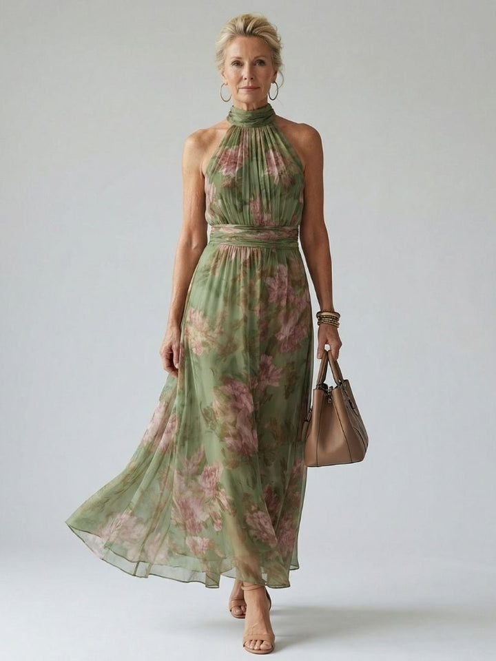 Woman wearing the Colette green floral halter midi dress with gathered neckline and flowing midi length