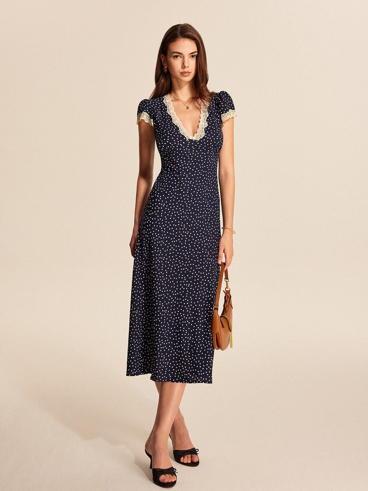Side view of navy polka dot cap sleeve midi dress showing A-line silhouette and midi length