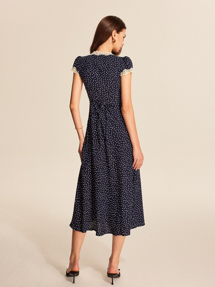 Detail shot of all-over polka dot print on deep navy fabric of the midi dress