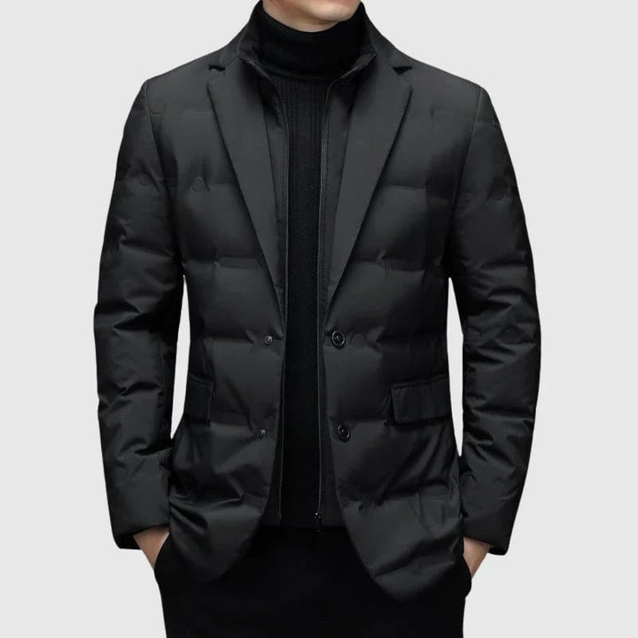 Model wearing a structured padded winter blazer in a neutral tone, front view showing clean tailored lines