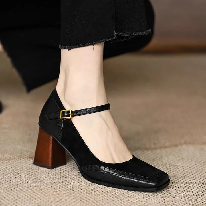 Constance black pump with gold ankle buckle detail, styled flat lay on neutral background