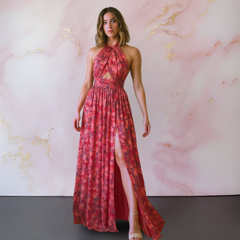Woman wearing a red and pink floral maxi dress with an open back and flowing silhouette, front view