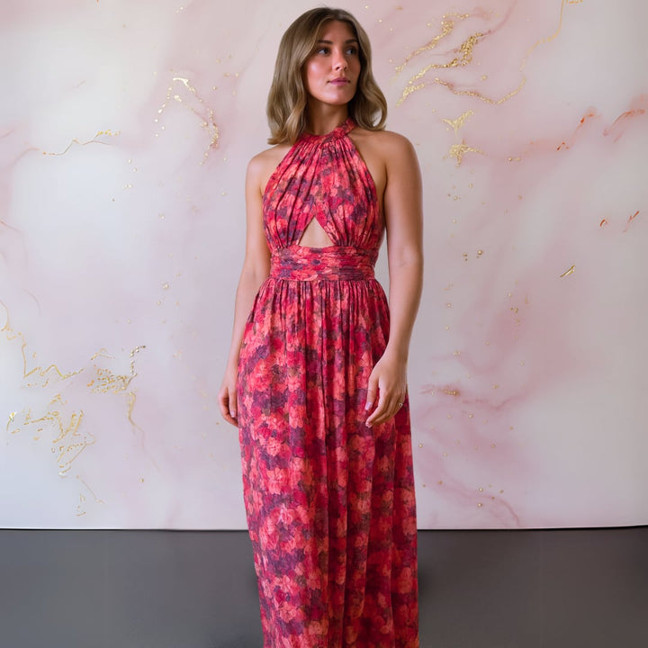 Close-up of red and pink floral print fabric on an elegant open-back maxi dress