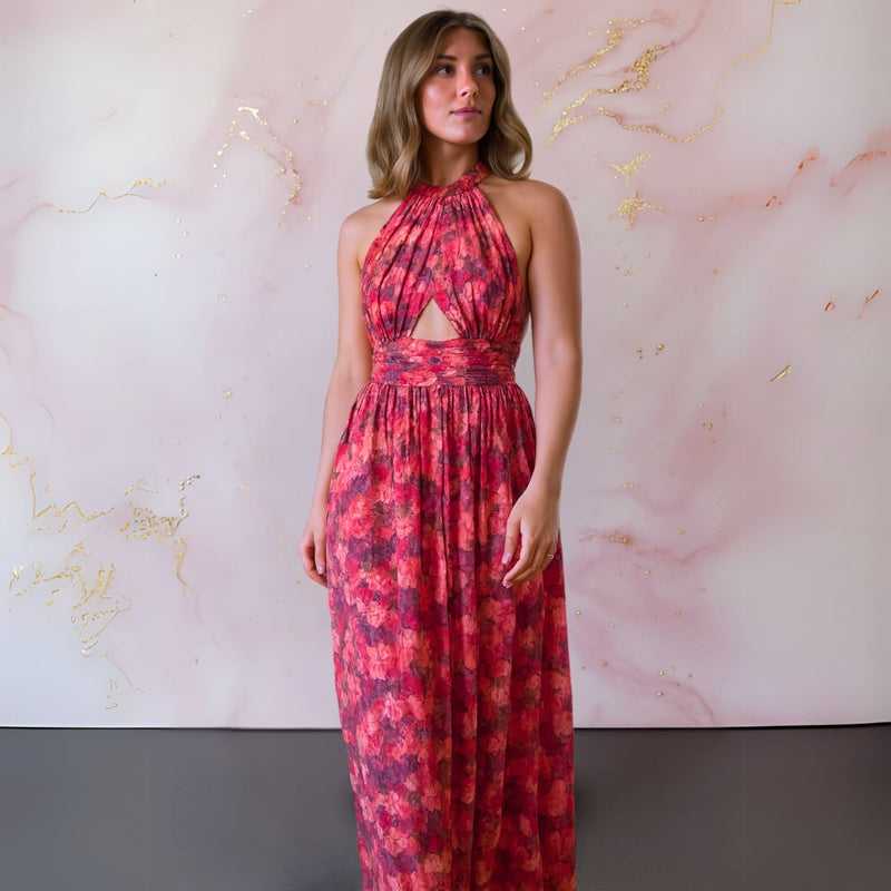 Close-up of red and pink floral print fabric on an elegant open-back maxi dress