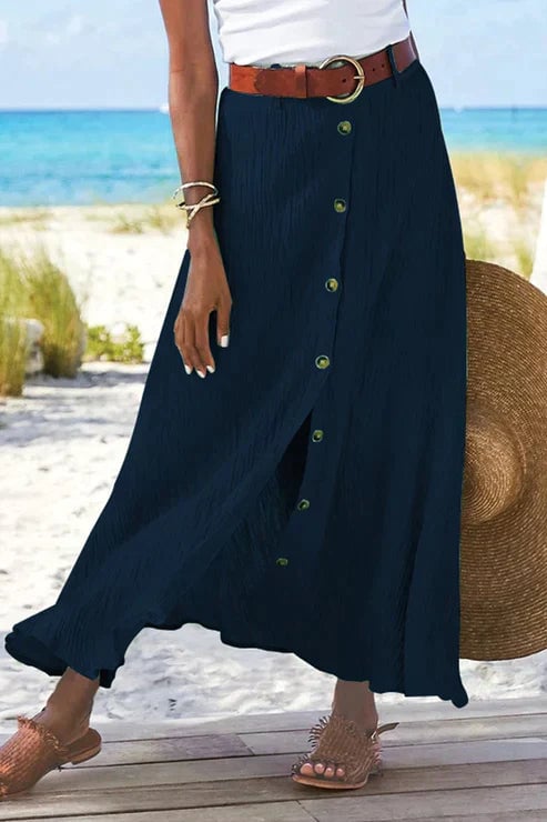 Model wearing the linen-look maxi skirt in white paired with a tucked-in cropped top and sandals