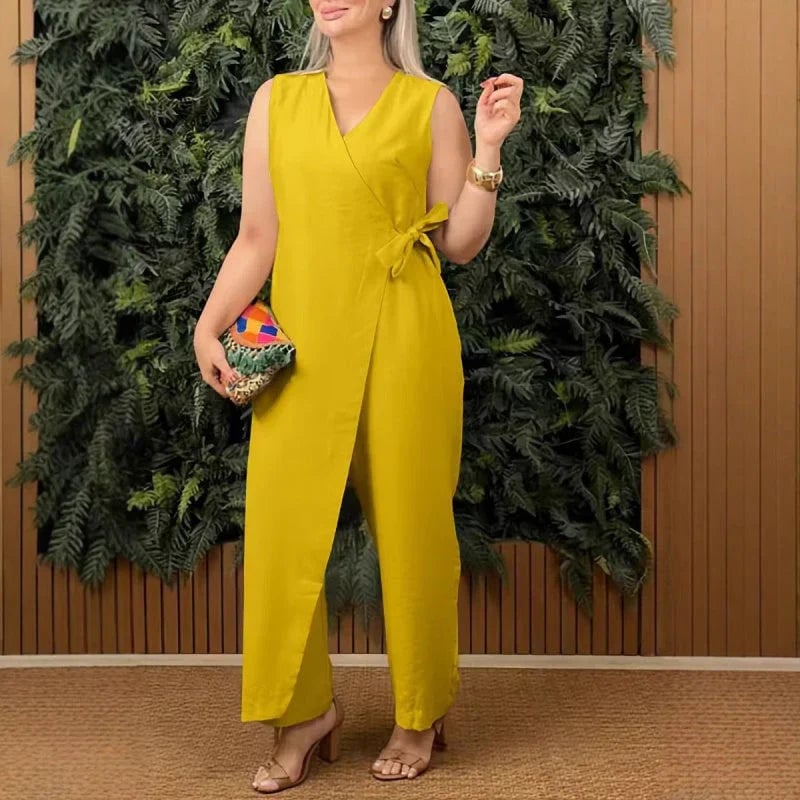 Woman styled in an orange wide-leg jumpsuit with strappy heeled sandals and gold jewelry