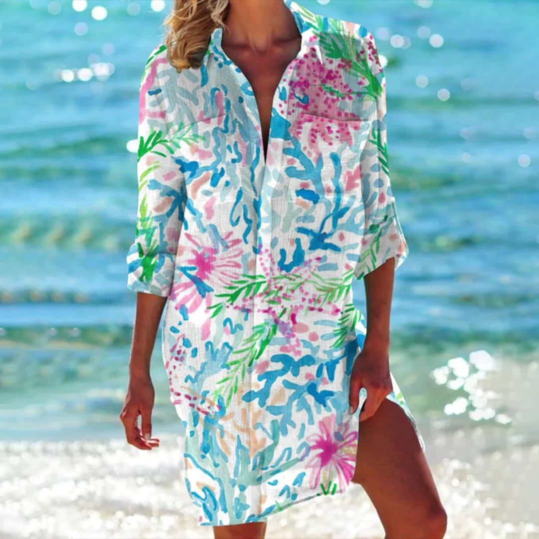 Women wearing a blue tropical watercolor print midi shirt dress with 3/4 roll-tab sleeves and side slits