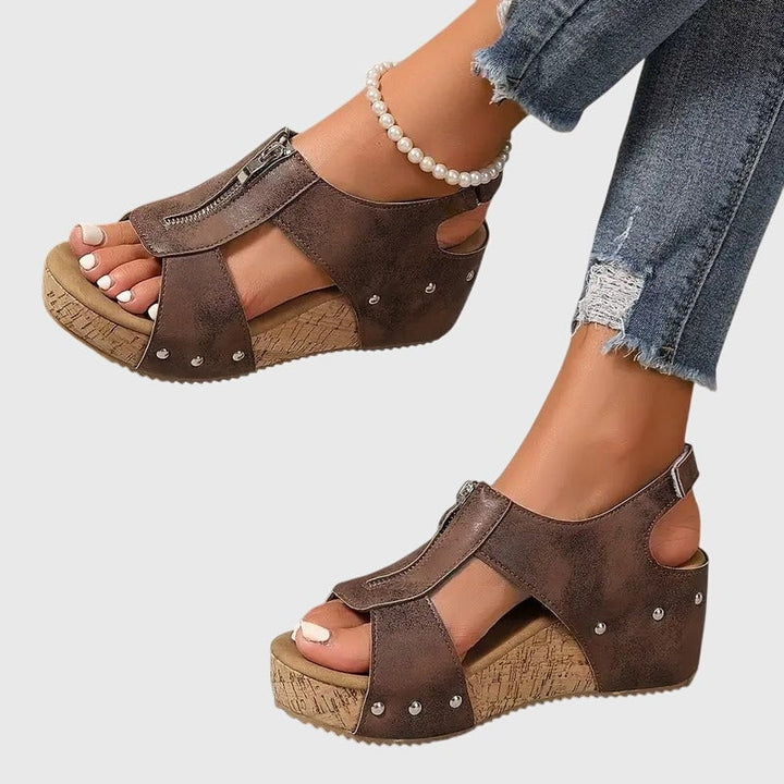 Close-up of Cordula sandal zipper detail in beige with adjustable strap hardware