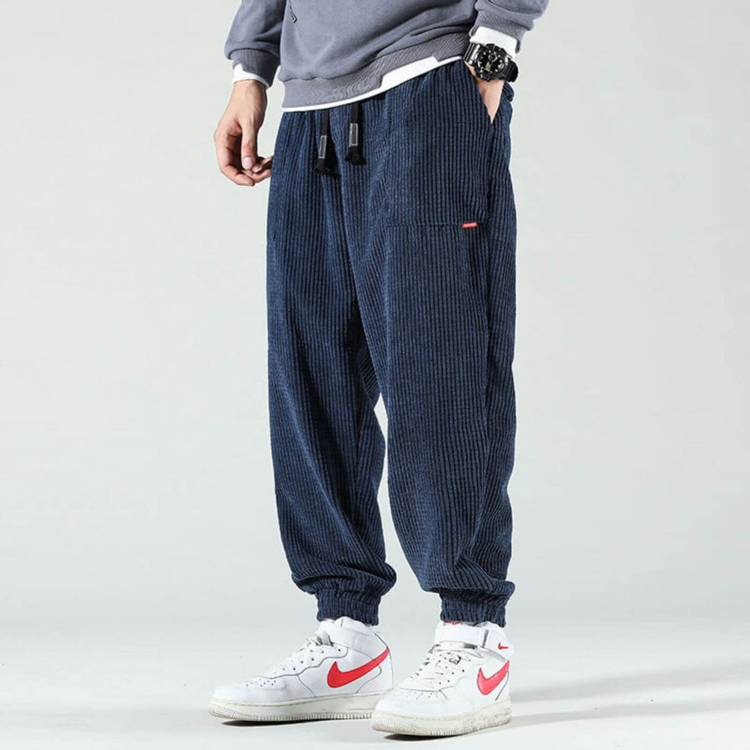 Model wearing marine blue classic corduroy joggers with a relaxed fit and tapered leg