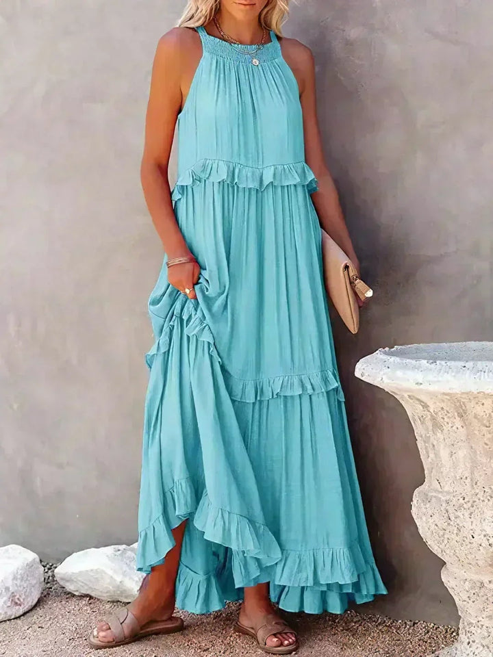 Model in the Courtney sleeveless ruffle dress in blue, styled for a summer occasion