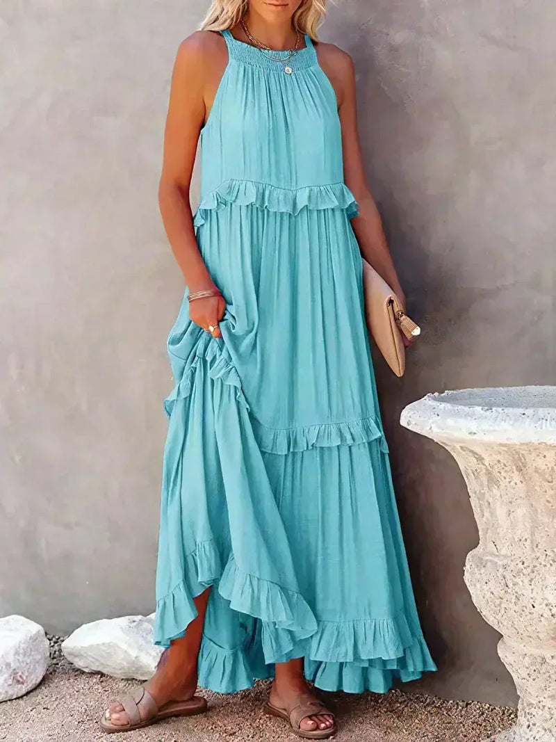 Model in the Courtney sleeveless ruffle dress in blue, styled for a summer occasion