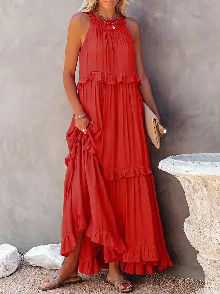 Courtney elegant sleeveless ruffle dress in red, worn by a smiling model outdoors
