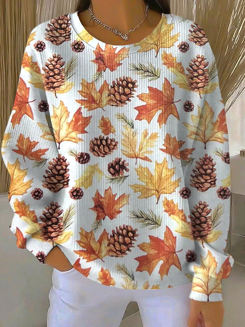Woman wearing a cozy relaxed-fit sweatshirt featuring a colorful maple leaf print, perfect for fall casual outfits