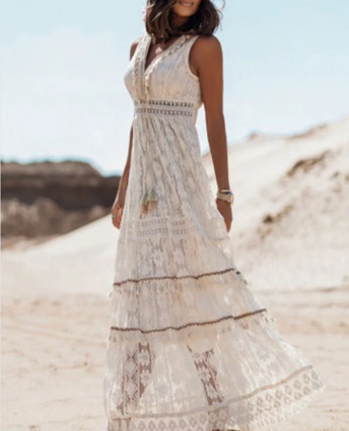 Full-length view of a woman in the Cynthia bohemian dress in beige, paired with sandals for a casual effortless look