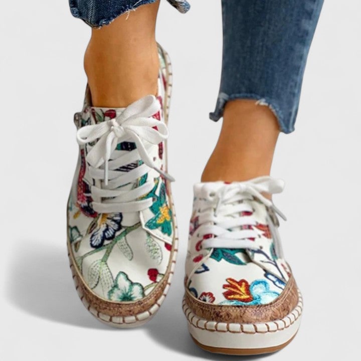 Flat-lay of all four Dahlia sneaker colorways — Bella Flora, Black Exotic, Blue Flora, and Pure White — arranged on a light background