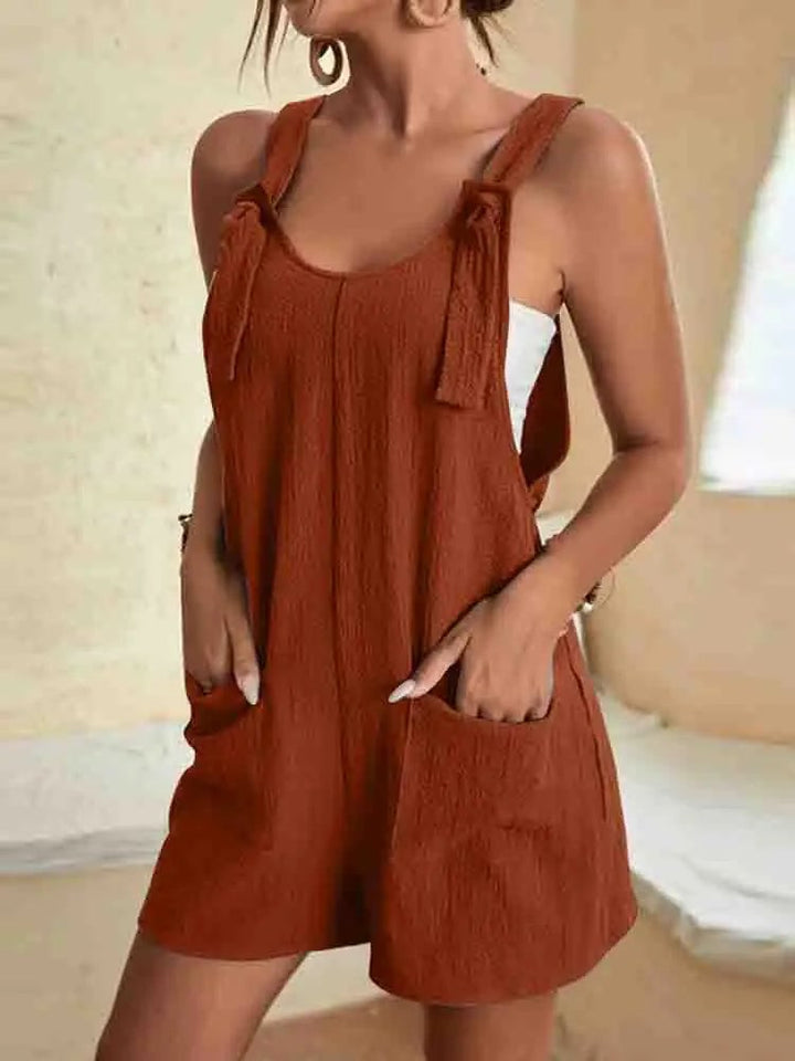 Woman styling the Daisy linen romper in green with sandals for a casual summer look