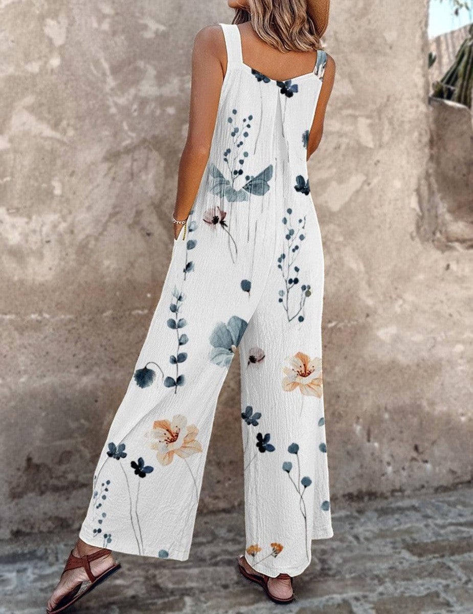 Close-up of the adjustable button shoulder straps and daisy print fabric on the white overalls jumpsuit