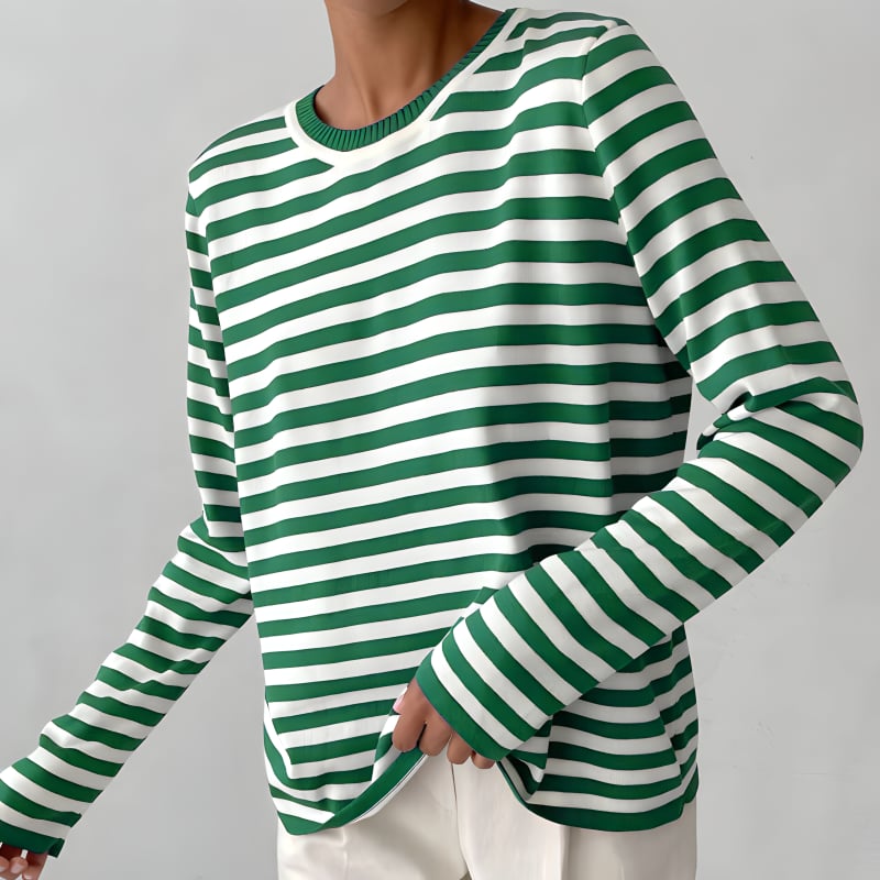 Woman modeling the Dana striped T-shirt in blue, tucked into high-waisted trousers for a polished daytime look