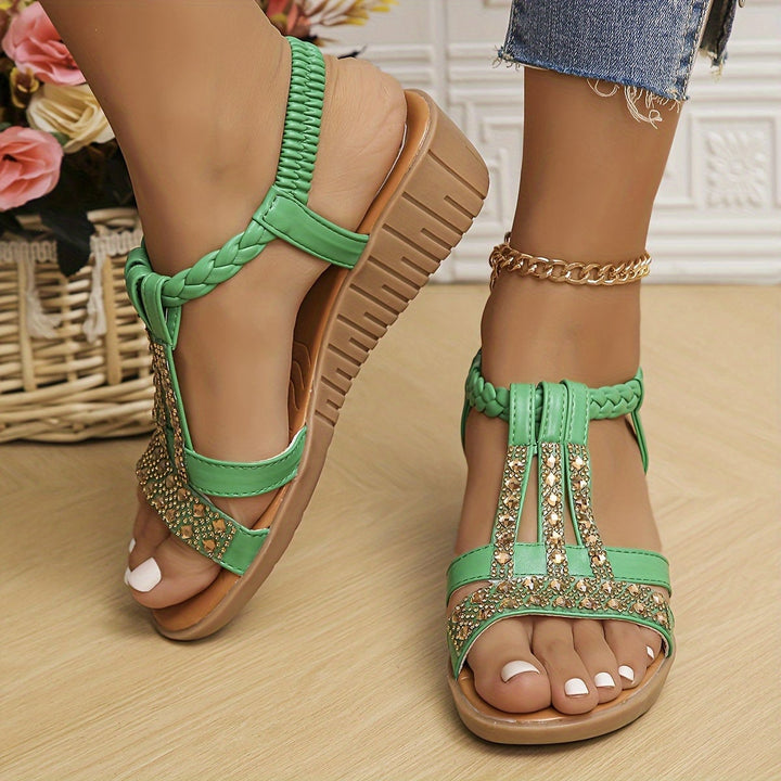 Top-down view of Darby rhinestone woven sandals in rose gold on a light surface