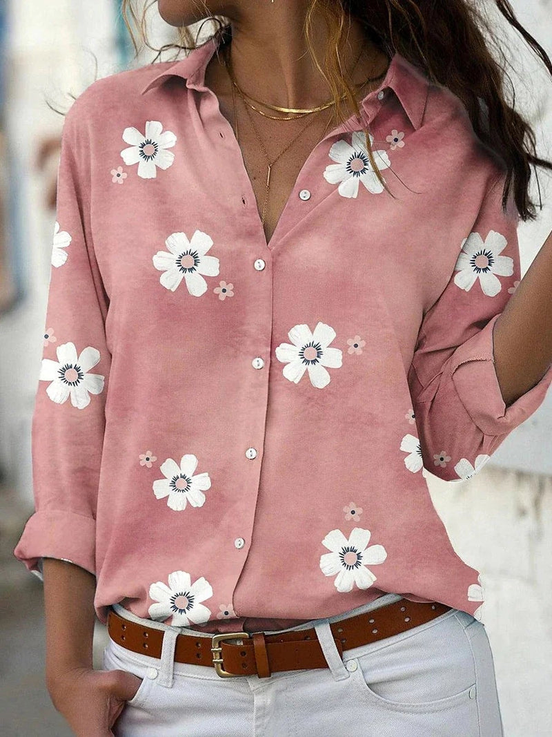 Woman wearing a floral print button-down blouse with a classic collar in a soft pink colorway