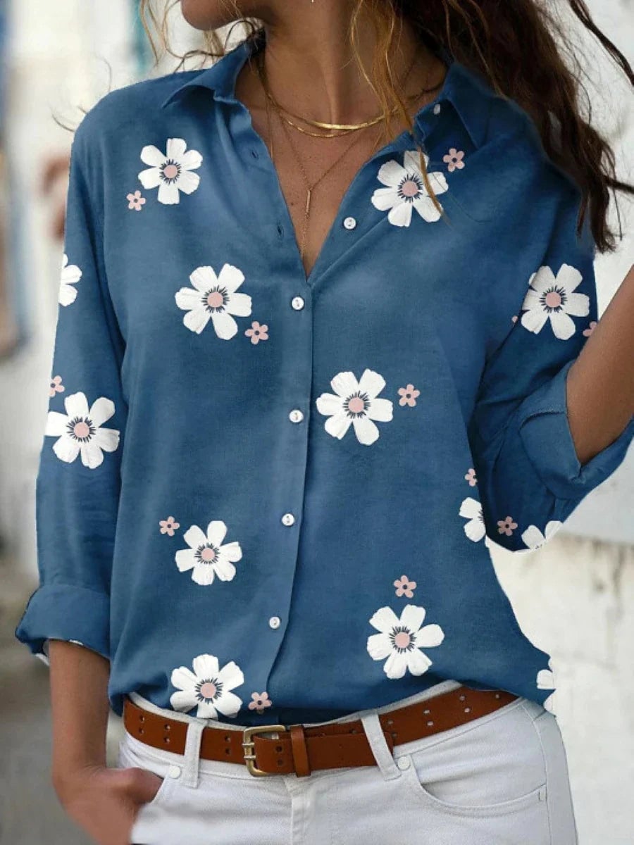 Model styled in a floral blouse tucked into tailored trousers for a polished, put-together look