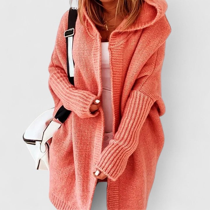 Close-up of cozy knit texture on an oversized hooded cardigan in orange