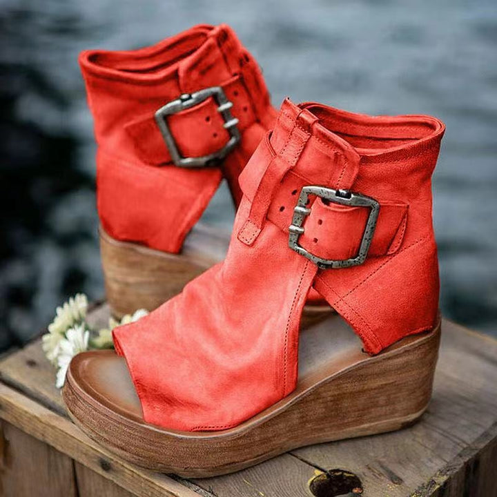 Red boho wedge sandals with buckle closure, side view on white background