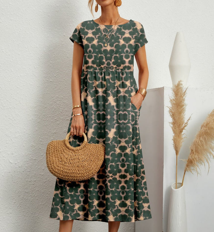 Woman wearing an elegant floral dress in a relaxed flared silhouette, shown in dark green with a delicate print pattern
