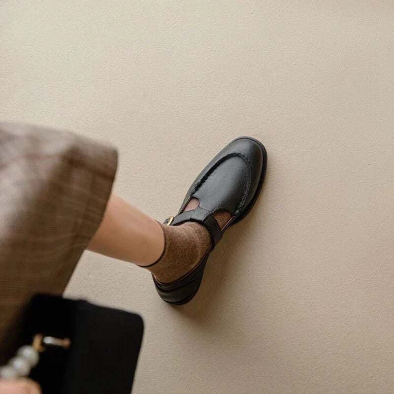 Close-up of gold-tone T-strap buckle closure on Delia black Mary Jane shoes