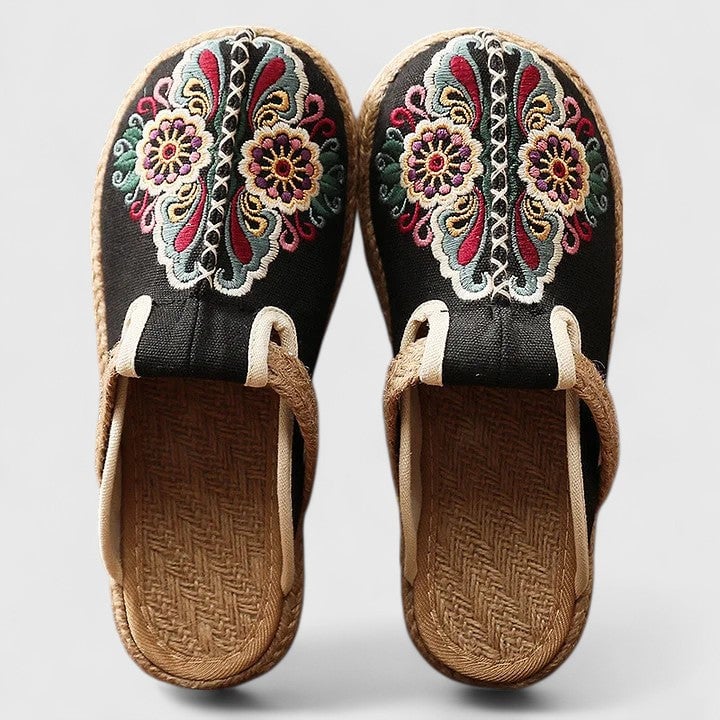 Delphina mules styled in white colorway displaying delicate floral embroidery on a clean upper