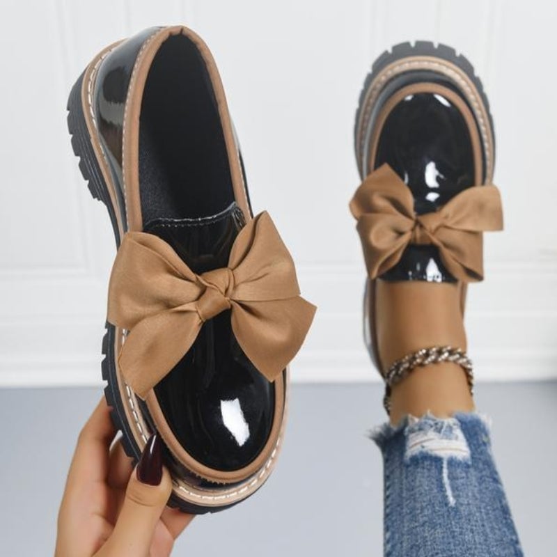 Demi bow platform loafers in beige patent-look finish with oversized structured bow, side view