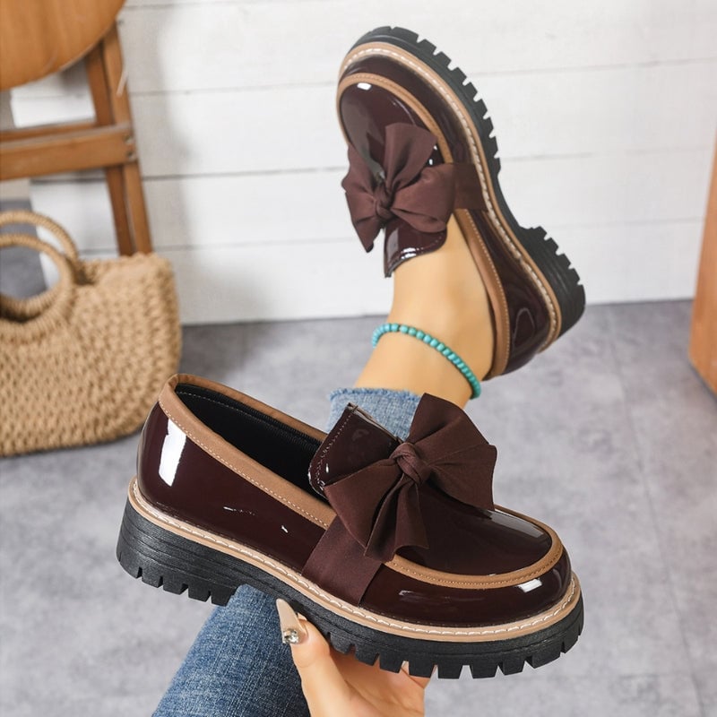 Demi platform loafers in green slip-on style, shown on a model's feet with cropped trousers