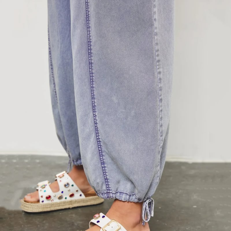 Front view of the Demi denim wide-leg jumpsuit in dark blue with smocked waist and side pockets
